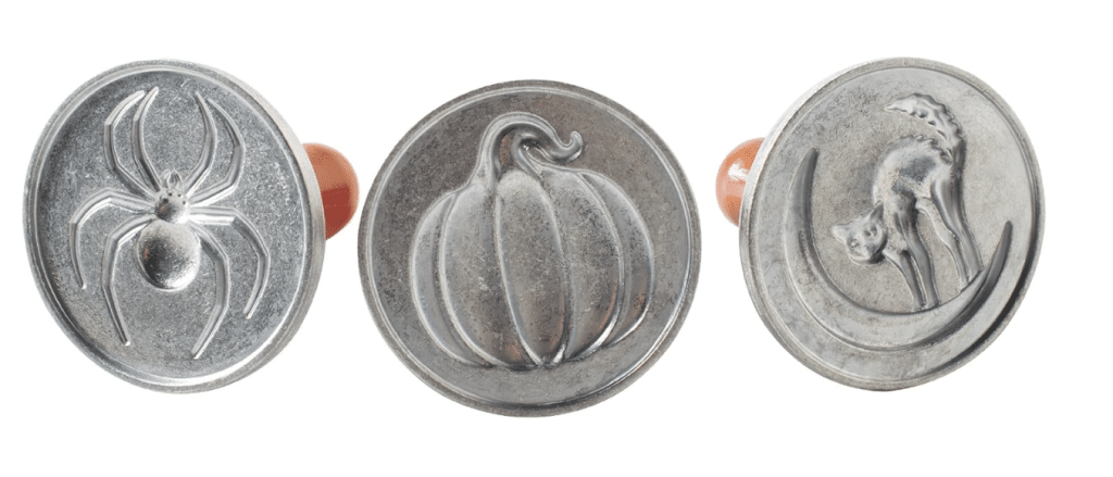 Three round cookie stamps with Halloween designs: a spider, a pumpkin, and a cat on a crescent moon. Made of metal with a short handle in the back, they're perfect for crafting spooky Halloween treats for kids.